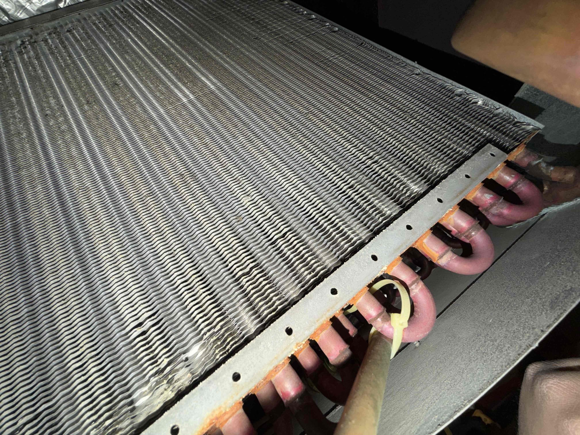 Upon arrival, I inspected the unit, which the client reported was running fine. I began by examining the system for any visible faults but found none. I removed the bottom door to inspect the coil for cleanliness and found it to be in good condition. Interestingly, as I removed the coil door and the pressure decreased, the temperature increased, which is contrary to known heat transfer principles. The system had been exhibiting odd issues, and even the client's brother-in-law, an HVAC professional, could not identify the problem.