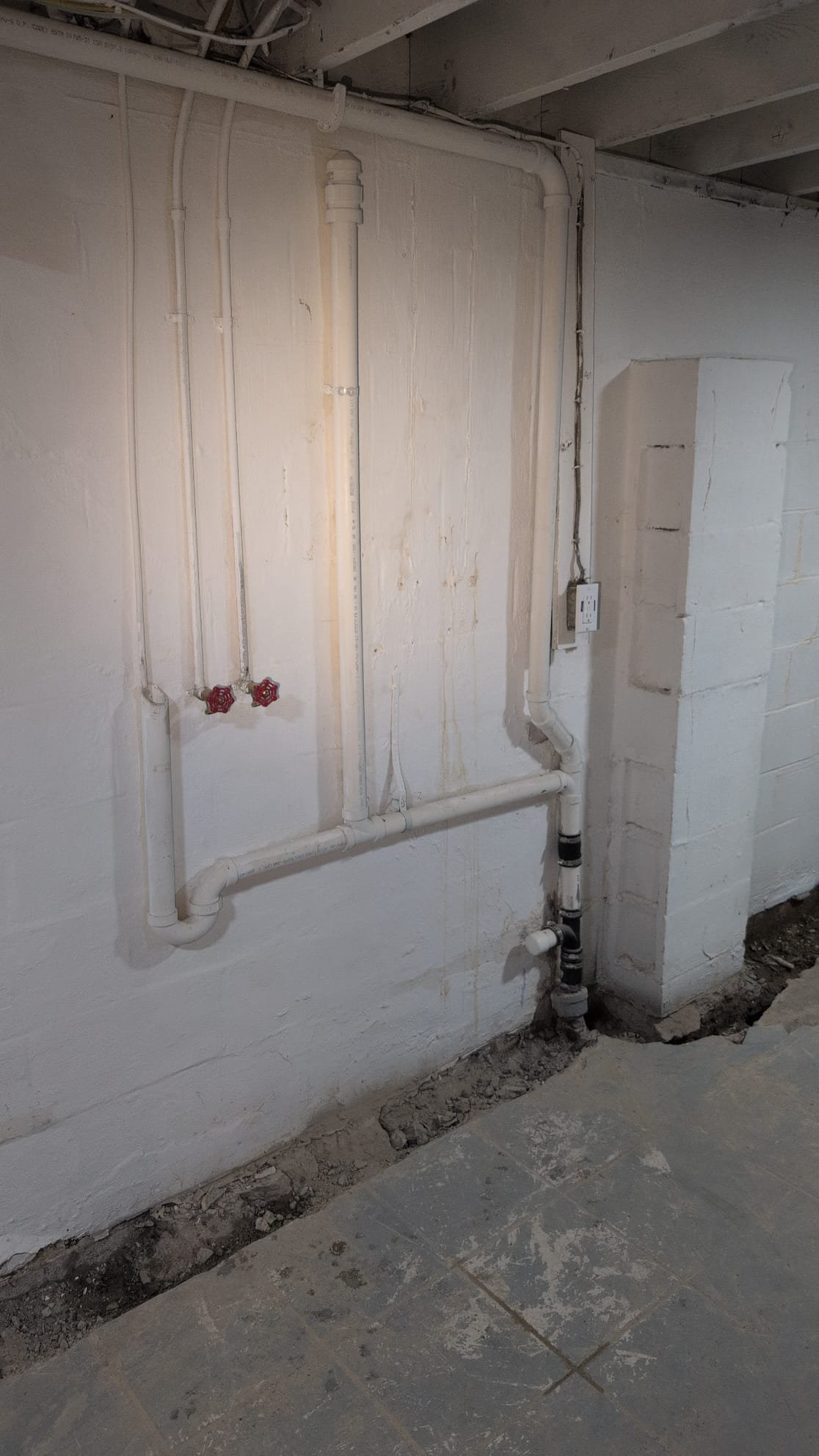 Today, we were called to address an issue in the basement. While waterproofing contractors were working, they discovered a collapsed drain line. This line connects only to the kitchen faucet and the washing machine drain. Upon inspection, I noticed a section of galvanized pipe beneath the floor. Running the water revealed movement, confirming the leak's location. To fully expose the line, we had to jackhammer slightly more. The client was informed about the possibility of further collapse further down the line. Our focus was on ensuring the line was properly exposed and assessed for any additional damage.