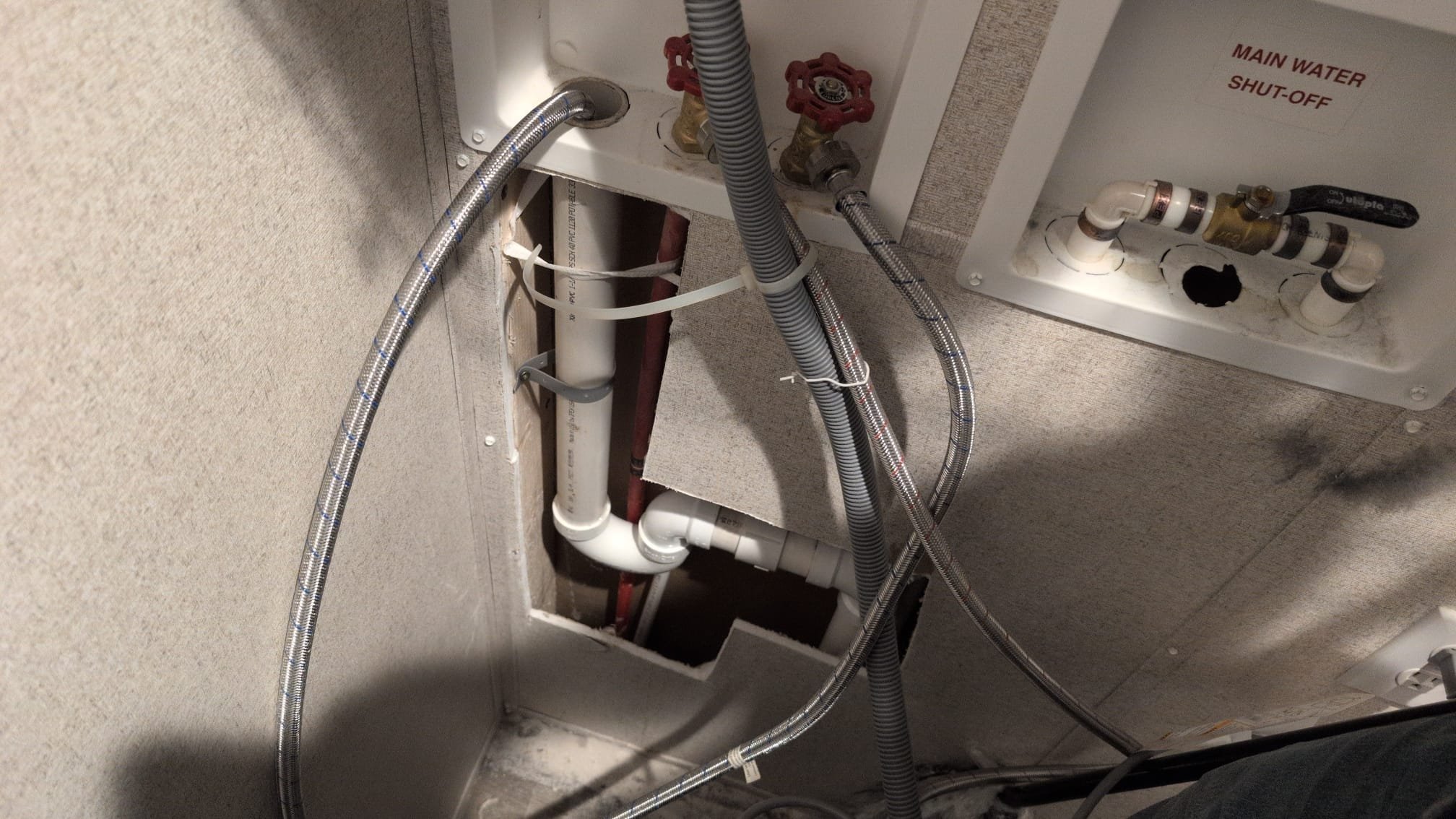 The client contacted us due to recurring water issues after using their washing machine. I inspected the previous work, which included a coupling and a p-trap connected to the washer box. I tested the cold inlet flex line at full blast and observed for leaks, finding none from the p-trap or the areas we had worked on. However, I noticed the discharge line to the washing machine was inadequately secured, likely moving during water discharge. I concluded that the discharge tube's movement caused the water to spray. I securely strapped the discharge line to prevent future movement, ensuring the issue is resolved.