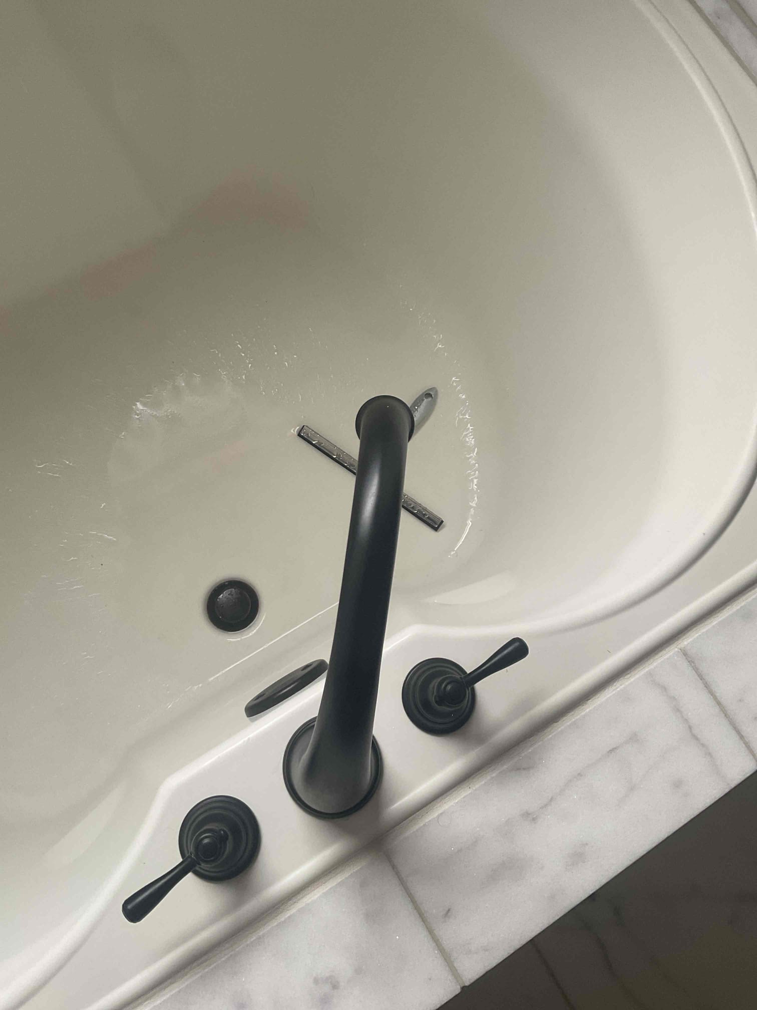 We were called for plumbing maintenance. Due to the water heater's age, installed in 2012, we did not flush it. The 50-gallon natural gas expansion tank was full of water, prompting an estimate for replacement. The client's home has a radon system and 2.5 bathrooms. A leak was confirmed from the first-floor half bath toilet, causing water to drip into the basement. An estimate was provided for a reset. Other toilets and laboratory pop-ups functioned well, with no water leaks observed. The standing showers and tub diverters operated correctly, with no dripping after use.