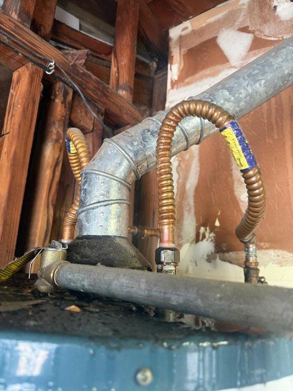 Responded to service call for residential water heater with bottom tank leak. Removed and disposed of failed unit, which had no visible tank information but was determined to be a 40 or 50 gallon gas atmospheric vent model. Installed new Richmond brand 40 gallon residential gas water heater in basement utility area. Connected water supply lines, gas line with flexible corrugated connector, and venting system through existing infrastructure. Installed temperature and pressure relief valve, tested all connections for leaks, and verified proper combustion and venting operation. Advised customer of permitting requirements and provided arrival window of 2-5 PM for installation appointment.