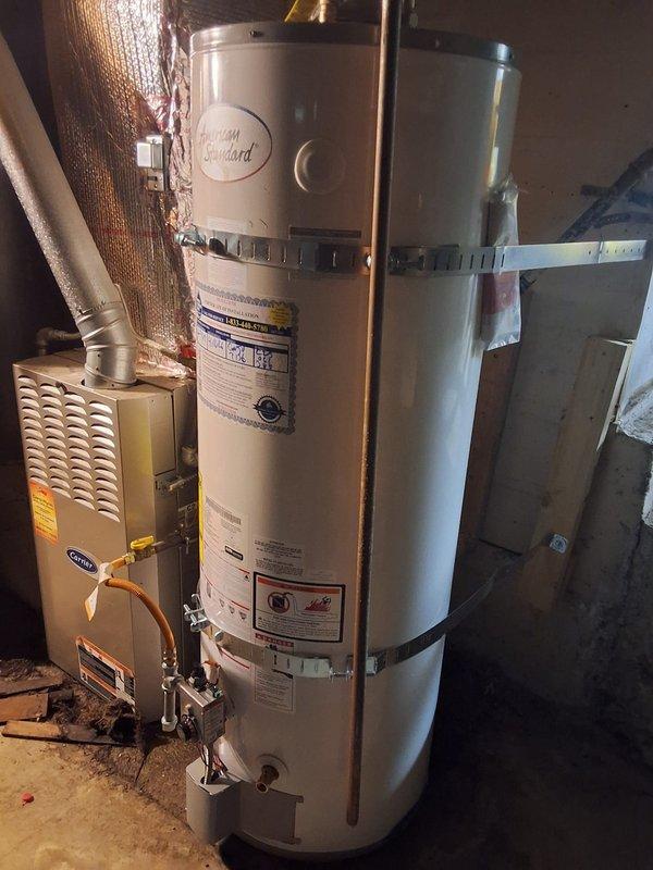 Replaced failed 1998 50-gallon gas water heater with new American Standard 50-gallon atmospheric gas water heater in basement utility room. Removed and properly disposed of old unit, installed new tank with copper supply line connections, established proper venting, and connected gas line with black flexible connector. Verified all connections for leaks, tested unit operation, and ensured compliance with local permitting requirements for residential water heater replacement.
