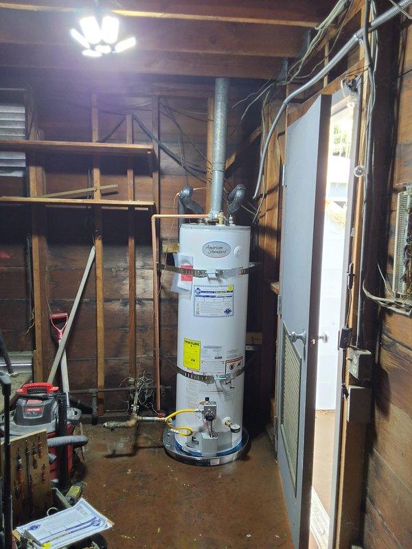 Replaced a 15-year-old 40-gallon gas water heater with a new American Standard 40-gallon gas unit as a preventative measure for a repeat customer with multiple properties. This was the second water heater replacement on this property within three months, addressing a separate tank. Installation included proper venting through existing ductwork, connection of gas supply line, hot and cold water piping, pressure relief valve with discharge piping, and placement on a metal drip pan. All connections were tested for leaks, gas line was pressure tested for safety, and unit was fired up and verified for proper operation. Permit requirements were discussed with the customer prior to installation.