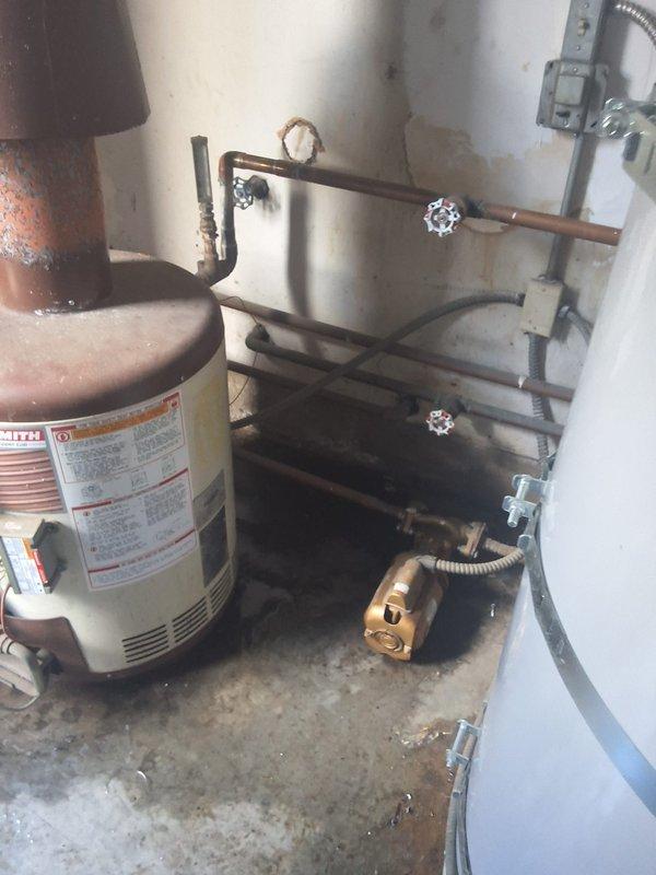 Conducted commercial estimate for water heating system replacement serving 12-unit residential building with one bathroom per unit. Existing water heater exhibits severe corrosion and deterioration at top section with active leaking, necessitating complete system replacement. Customer requested conversion from current boiler configuration to standard tank-type water heater installation, with follow-up site meeting scheduled to finalize equipment specifications and installation requirements.