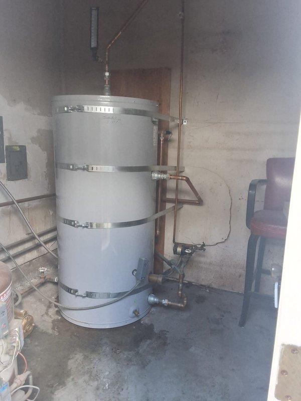 Conducted commercial estimate for water heating system replacement serving 12-unit residential building with one bathroom per unit. Existing water heater exhibits severe corrosion and deterioration at top section with active leaking, necessitating complete system replacement. Customer requested conversion from current boiler configuration to standard tank-type water heater installation, with follow-up site meeting scheduled to finalize equipment specifications and installation requirements.
