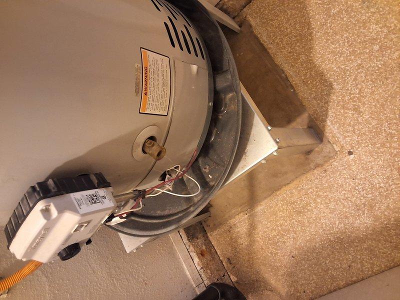 Performed inspection and estimate on aging 40-50 gallon gas water heater installed in attic space. Unit age and model information unavailable during assessment. Evaluated existing installation including ventilation configuration, condensate pump operation, and overall system condition. Documented equipment setup with cylindrical tank-style water heater, black flexible vent ducting, and associated condensate management system. Presented replacement options and discussed available payment methods with property owner.