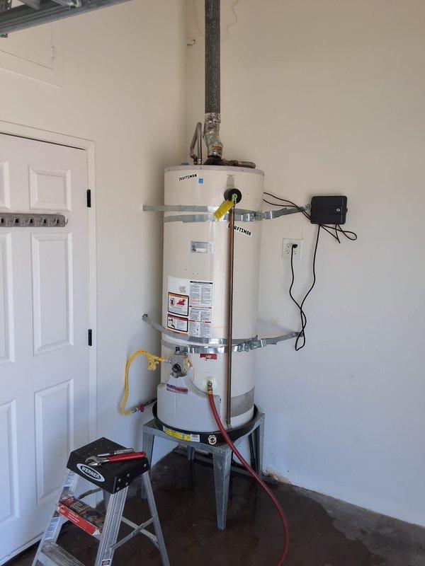 Responded to service call for leaking residential gas water heater. Upon inspection, determined existing 40-gallon gas water heater, approximately 10 years old, had developed a tank leak and was beyond economical repair. Removed and properly disposed of failed unit. Installed new 40-gallon gas water heater on elevated metal stand with seismic strapping at two levels per code requirements. Connected gas supply line, cold water inlet, and hot water outlet with appropriate piping and flexible connectors. Installed temperature and pressure relief valve with proper discharge piping terminating safely above floor level. Verified all connections for proper operation and tested for gas leaks. Unit secured with metal strapping bands for earthquake safety compliance. Confirmed proper venting through existing flue system. Advised customer of permitting requirements for installation. System tested and operational upon completion with no leaks detected.