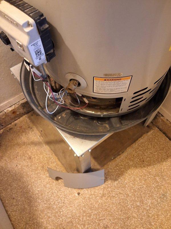 Completed installation of customer-supplied gas control valve on residential water heater model RG240T6N. Replaced defective gas control valve assembly with new white electronic control unit featuring integrated safety controls and electronic ignition system. Verified proper gas connections, tested all safety features, and confirmed unit operation upon completion.