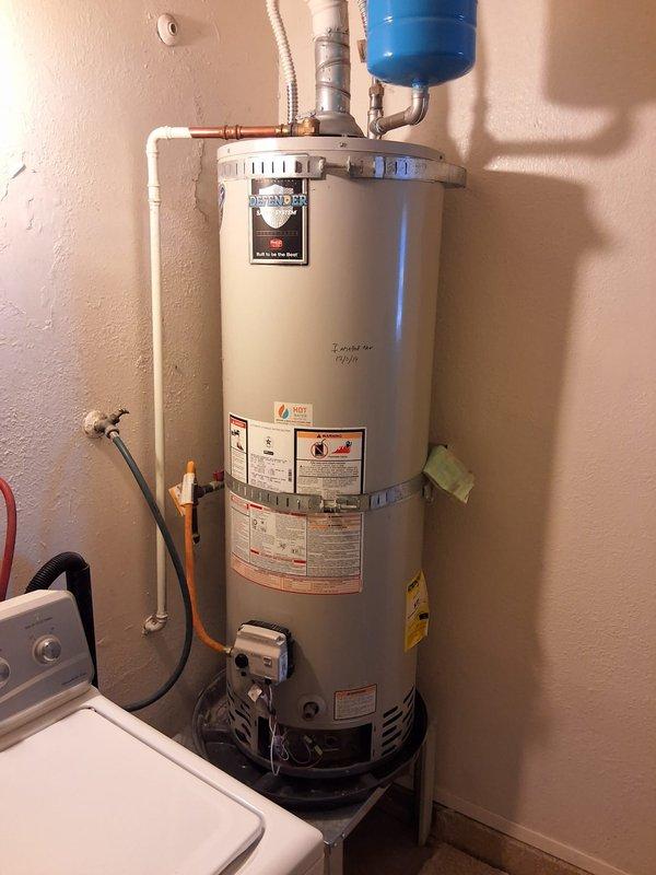 Completed installation of customer-supplied gas control valve on residential water heater model RG240T6N. Replaced defective gas control valve assembly with new white electronic control unit featuring integrated safety controls and electronic ignition system. Verified proper gas connections, tested all safety features, and confirmed unit operation upon completion.