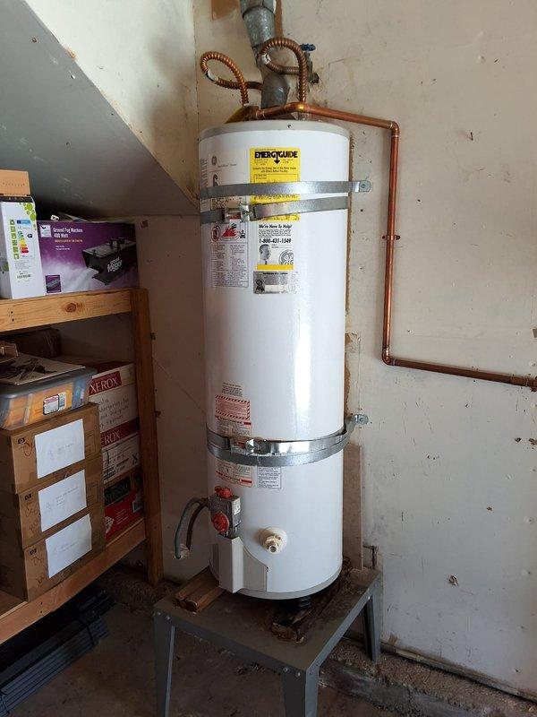 Completed conversion from 40-gallon gas tank water heater (Model GG40T6XA) to tankless system with installation of Navien NPE-210S2 unit. Removed existing tank water heater from garage/utility area and installed new tankless water heater with supporting components including 3/4" pressure reducing valve, isolation kit, and 1-gallon expansion tank. All copper piping connections completed, gas line converted for tankless operation, and venting system installed per manufacturer specifications. Permit obtained and work performed in compliance with local plumbing codes. System tested for proper operation, temperature settings configured, and all safety controls verified functional.