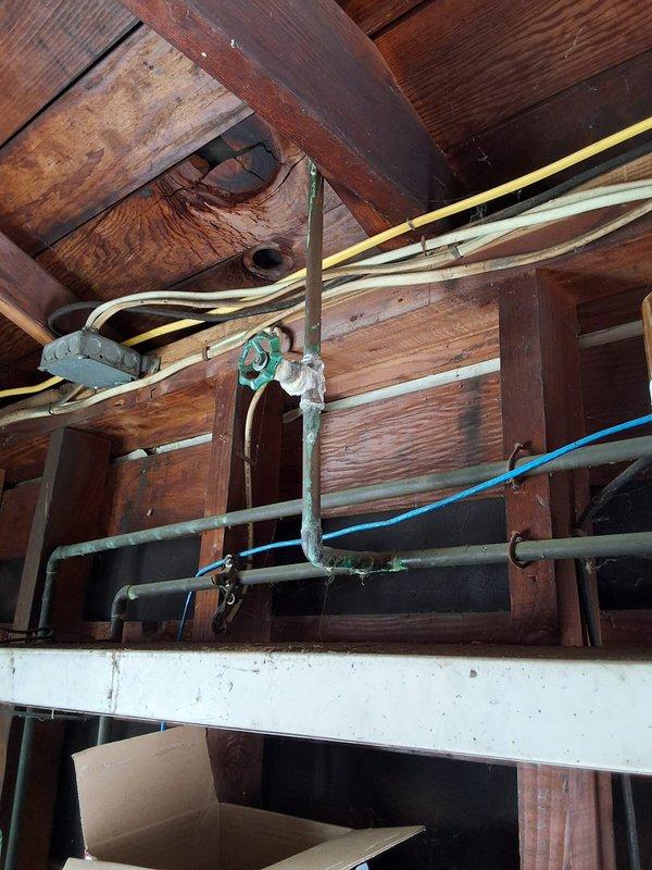 Performed inspection and estimate for conversion from existing 30-gallon gas water heater to tankless gas system. Evaluated current installation including kitchen gas water heater and solar storage tank in garage to assess solar system functionality and compatibility with proposed tankless conversion. Documented existing plumbing infrastructure, gas lines, venting requirements, and electrical connections. Photographed current water heater installation, surrounding framing, gas and water supply lines, and overhead utility routing to develop comprehensive conversion proposal including necessary permits and installation requirements.