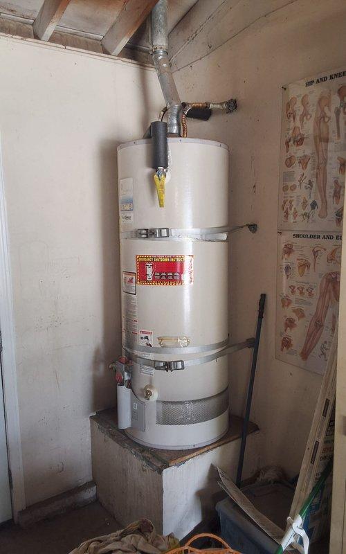 Provided estimate for replacement of existing 2007 50-gallon gas water heater currently located in garage. Offered GN50T1-3 model 50-gallon gas water heater as part of summer promotion, with pricing to include necessary code compliance modifications and county permit fees. Customer advised of county permitting requirements and associated costs. Scheduled installation appointment with arrival window confirmed for Saturday morning between 9:00 AM and 12:00 PM. Documented existing water heater installation with photographs showing current unit condition, venting configuration, and installation location for reference during replacement work.