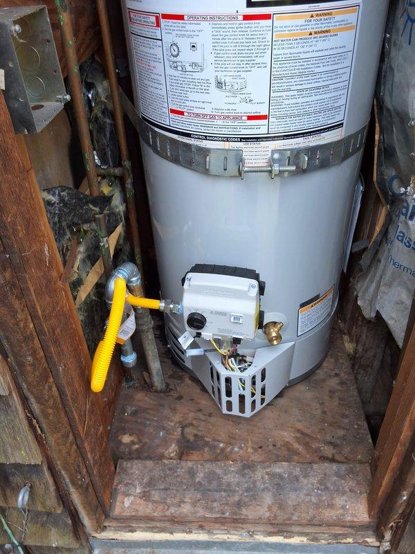 Completed residential water heater replacement with installation of a 30-gallon natural gas unit (model URG130T6N) in an exterior wooden enclosure. The installation included all necessary plumbing connections, gas line hookup with flexible yellow connector, pressure relief valve, drain pan, and proper venting. All safety labels and operational instructions are clearly visible on the unit, and the system was tested and confirmed operational upon completion.