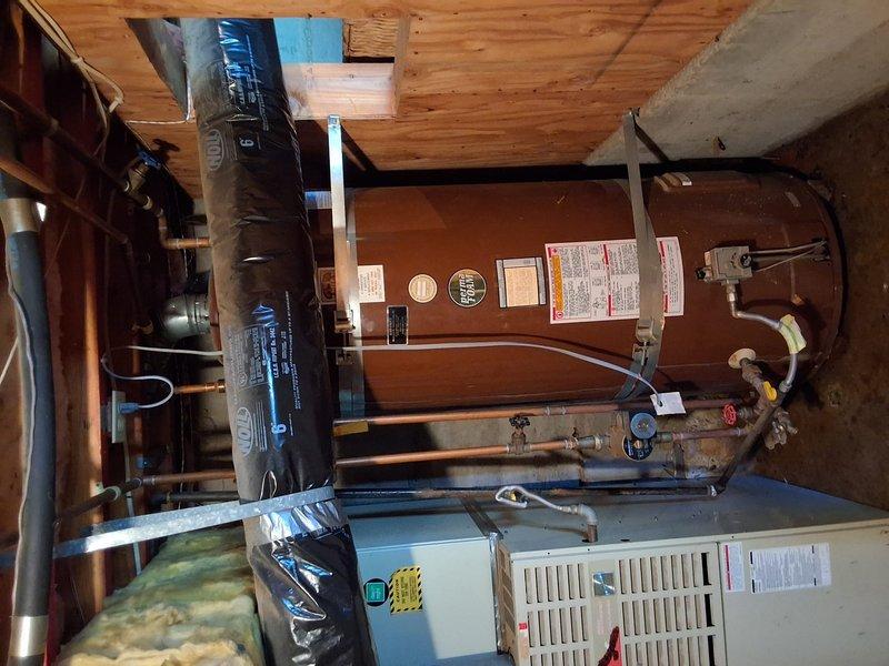 Responded to service call for leaking water heater in basement. Inspected existing 100-gallon gas water heater and documented current installation with photographs showing unit, piping configuration, and mechanical room layout. Discussed replacement options including 50-gallon gas, 50-gallon electric, and tankless gas systems. Provided customer with information regarding permit requirements for water heater replacement and presented ballpark estimates for tankless installation.