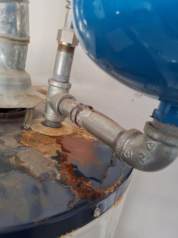 Responded to a leak at the expansion tank connection on a 2020 50-gallon gas water heater located in the garage. Upon inspection, discovered the previous installer had used galvanized fittings at the expansion tank connection point, which caused corrosion and water leakage. Diagnosed the issue and provided repair options including replacement of the galvanized fittings with proper brass fittings, as well as the option to replace the expansion tank if needed. Documented the condition with photographs showing significant rust and corrosion at the tank top and pipe connections. Scheduled follow-up appointment for repair work.
