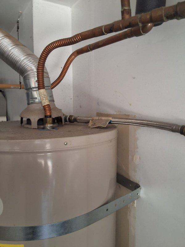 Replaced a 2007 AO Smith GVR50100 water heater with a new 50-gallon gas atmospheric vent unit due to no hot water condition. Installation included proper earthquake strapping, flexible copper connectors for thermal expansion, corrugated stainless steel water lines, and aluminum exhaust venting per code requirements. Customer was advised of permitting requirements and arrival window was scheduled for Saturday between 1-4 PM.