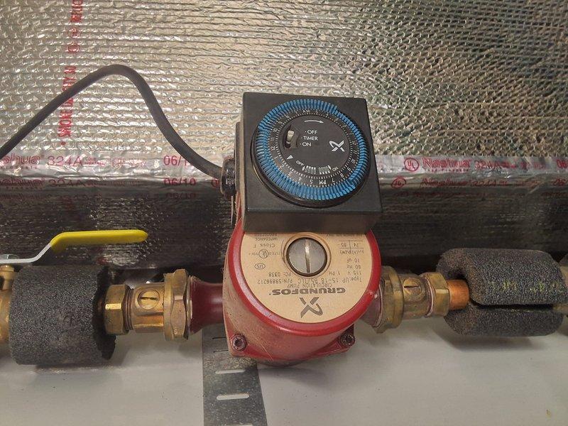 Responded to service call for hot water circulation pump model URG250L6N producing noise when timer was active. Upon inspection, diagnosed issue with timer control unit on Grundfos recirculation pump. Noise ceased when timer was switched to off position, confirming timer mechanism as source of malfunction. Evaluated pump assembly mounted on horizontal piping with brass compression fittings and verified all plumbing connections were secure. Documented existing installation including control unit with blue dial featuring OFF, AUTO, and ON settings. Recommended timer replacement to resolve operational noise issue and restore proper automated circulation function.