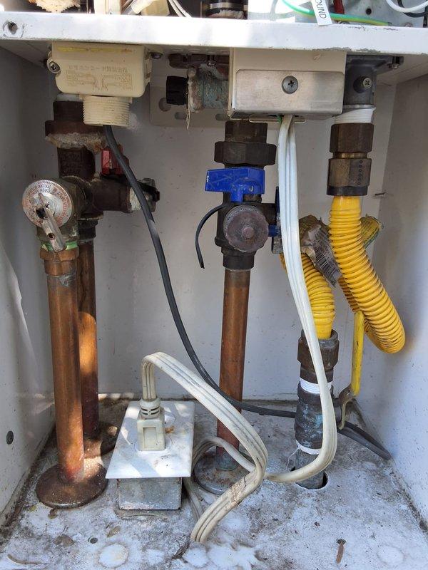 Performed preventive maintenance inspection on two tankless water heater systems at residential property. Evaluated plumbing connections, isolation valves, and gas supply lines, noting visible corrosion on copper piping, mineral deposits in equipment compartment, and aging valve components. Documented system condition with photographs showing corrugated gas flex line, shut-off valves, and pressure relief connections requiring monitoring for future service needs.