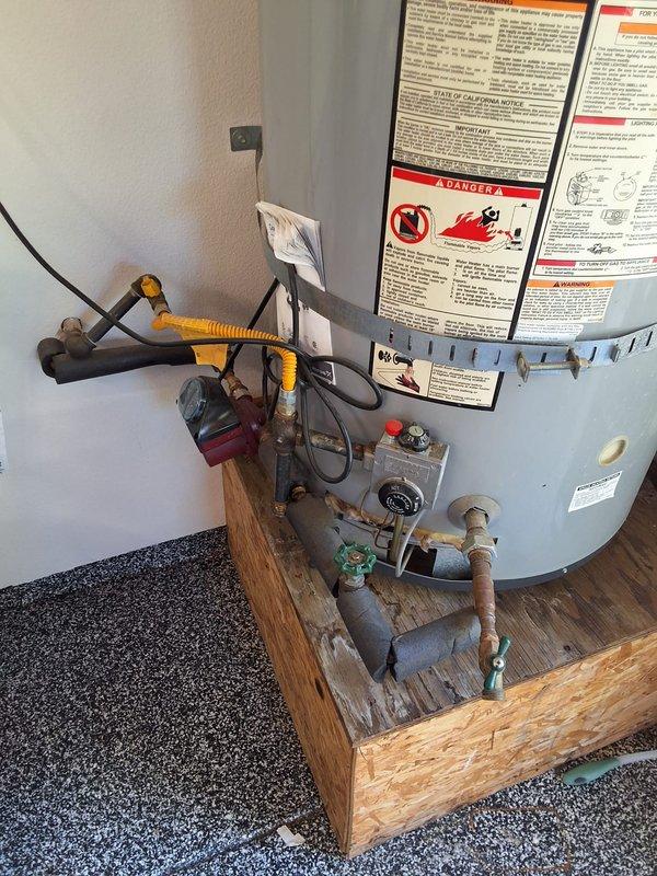 Responded to service call for leaking water heater. Upon inspection, found 21+ year old American brand residential gas water heater showing signs of age and active leak. Unit installed on wooden platform in utility closet with standard gas, water, and electrical connections. Evaluated existing installation including flexible gas line, copper water piping, pressure relief valve, and venting system. Discussed multiple replacement options with customer including traditional tank-style water heater, tankless water heater conversion, and heat pump water heater conversion. Provided estimates for like-for-like replacement as well as upgraded efficiency options. Reviewed permit requirements for replacement work. Documented existing installation with photographs showing current equipment condition, piping configuration, gas connections, and available space constraints. Customer to review options and schedule replacement service. Available payment methods confirmed.