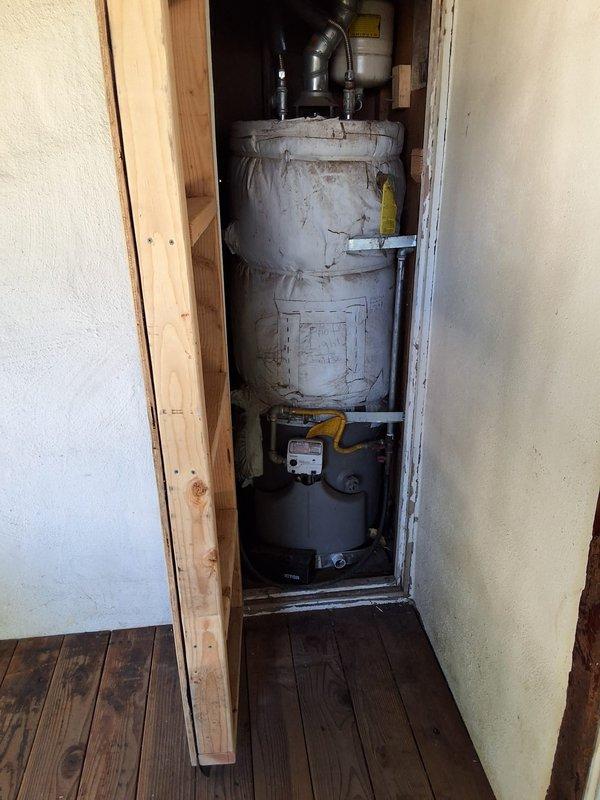 Responded to service call for aging 40-50 gallon gas water heater with reported leak at tank. Performed thorough inspection of unit installed in utility closet, noting visible deterioration, discoloration, and dust accumulation consistent with extended service life. Confirmed active leak originating from tank body, indicating internal corrosion and structural failure beyond economical repair. Evaluated all plumbing connections, gas line connections with yellow-handled shutoff valve, black corrugated vent piping, and burner assembly at base of unit. Discussed repair versus replacement options with customer, explaining that tank leaks require full unit replacement as welding or patching compromised tank integrity is not feasible or code-compliant. Provided detailed estimate for complete water heater replacement including new unit installation, and explained permit requirements apply to replacement work but not to repair attempts. Customer opted to receive formal replacement estimate. Doc