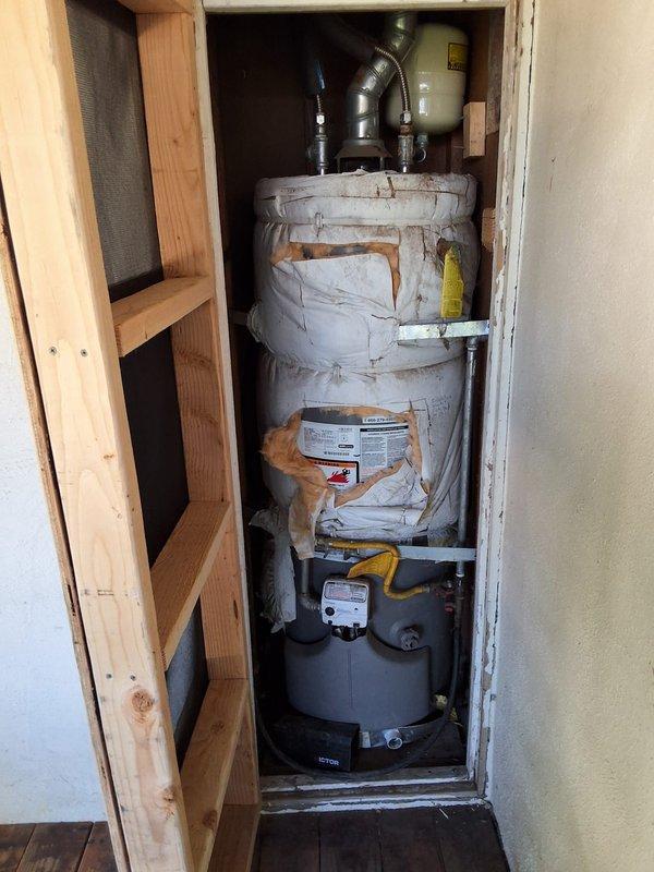 Responded to service call for aging 40-50 gallon gas water heater with reported leak at tank. Performed thorough inspection of unit installed in utility closet, noting visible deterioration, discoloration, and dust accumulation consistent with extended service life. Confirmed active leak originating from tank body, indicating internal corrosion and structural failure beyond economical repair. Evaluated all plumbing connections, gas line connections with yellow-handled shutoff valve, black corrugated vent piping, and burner assembly at base of unit. Discussed repair versus replacement options with customer, explaining that tank leaks require full unit replacement as welding or patching compromised tank integrity is not feasible or code-compliant. Provided detailed estimate for complete water heater replacement including new unit installation, and explained permit requirements apply to replacement work but not to repair attempts. Customer opted to receive formal replacement estimate. Doc