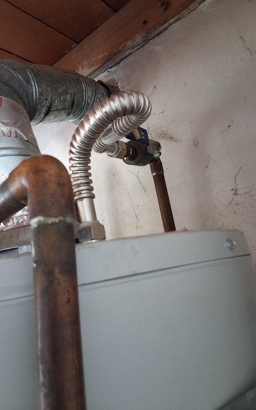 Responded to service call for leaking water heater in residential basement utility area. Upon inspection, found 8-year-old URG150T6N unit with active leak, unable to definitively determine if leak originated from tank body or temperature/pressure relief valve due to corrosion and water damage. Noted significant oxidation on copper supply piping and water staining on ceiling above unit, indicating prolonged moisture exposure. After evaluation, determined tank replacement was necessary due to age and extent of leak. Removed existing failed water heater and installed new residential gas water heater with appropriate permits. Connected new unit to existing copper supply lines, gas line, and venting system. Tested all connections for leaks, verified proper combustion and venting operation, and confirmed adequate hot water delivery throughout residence.