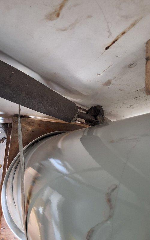 Responded to service call for leaking water heater in residential basement utility area. Upon inspection, found 8-year-old URG150T6N unit with active leak, unable to definitively determine if leak originated from tank body or temperature/pressure relief valve due to corrosion and water damage. Noted significant oxidation on copper supply piping and water staining on ceiling above unit, indicating prolonged moisture exposure. After evaluation, determined tank replacement was necessary due to age and extent of leak. Removed existing failed water heater and installed new residential gas water heater with appropriate permits. Connected new unit to existing copper supply lines, gas line, and venting system. Tested all connections for leaks, verified proper combustion and venting operation, and confirmed adequate hot water delivery throughout residence.