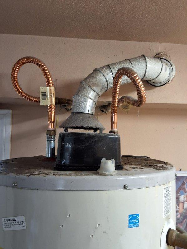 Responded to service call for leaking 50-gallon gas water heater (model GN50T1-3-6) located in garage. Performed thorough inspection of unit and surrounding plumbing connections, including flexible copper connectors, galvanized supply lines, expansion tank, and gas line. Documented existing installation with photographs showing water heater configuration, top-mounted connection assembly, corrugated flexible water lines, expansion tank with connecting piping, and yellow flexible gas supply line. Assessed overall system condition and identified source of leak. Provided estimate for complete water heater replacement including new unit installation and necessary permits, with customer advised of permitting requirements.