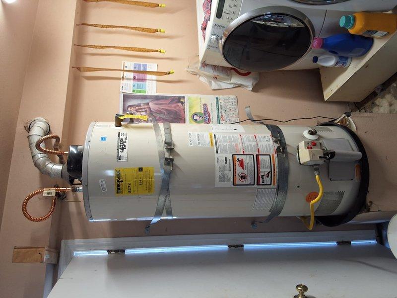 Responded to service call for leaking 50-gallon gas water heater (model GN50T1-3-6) located in garage. Performed thorough inspection of unit and surrounding plumbing connections, including flexible copper connectors, galvanized supply lines, expansion tank, and gas line. Documented existing installation with photographs showing water heater configuration, top-mounted connection assembly, corrugated flexible water lines, expansion tank with connecting piping, and yellow flexible gas supply line. Assessed overall system condition and identified source of leak. Provided estimate for complete water heater replacement including new unit installation and necessary permits, with customer advised of permitting requirements.