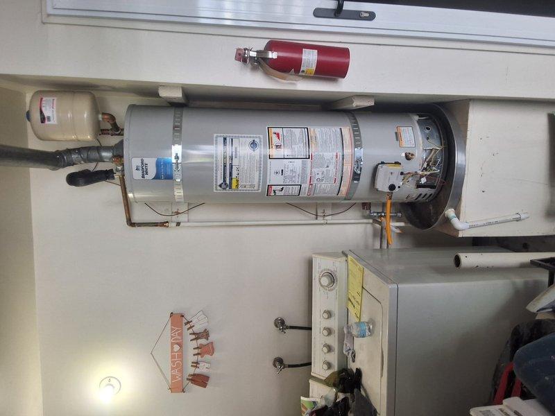 Responded to service call for leaking Bradford White 50-gallon gas water heater servicing a 3-bathroom residence. Removed and disposed of failed unit, then installed new American Standard 50-gallon gas water heater with proper venting and copper piping connections. Installed expansion tank, completed all code-required safety components including T&P relief valve, gas line connections, and combustion air venting, obtained and finalized permit for installation, and tested system for proper operation and leak-free performance.