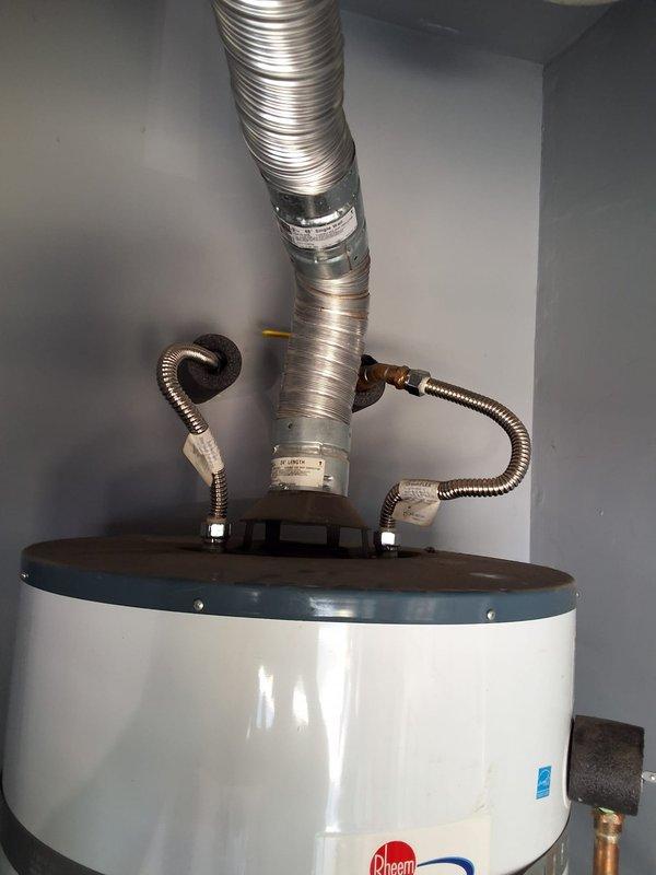Replaced a 50-gallon gas water heater (model GN50T1-3-6) in garage due to slow leak. Installation included proper venting with metallic flexible duct, gas line connections with braided flexible conduit, copper water line connections, wall-mounted expansion tank, and drain pan for code compliance. All work performed with permit and according to local building codes.