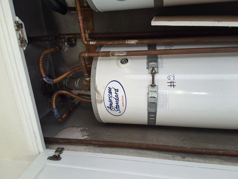 Replaced failed 30-gallon gas water heater with new American Standard unit. Removed old water heater from exterior utility closet, installed replacement tank with proper seismic strapping per code requirements, and connected all copper supply lines, gas flex connectors, and temperature/pressure relief valve discharge piping. Tested all connections for leaks, verified proper gas combustion and venting, and confirmed hot water delivery to fixtures. Contacted office with findings and evaluation as requested per property management protocol.