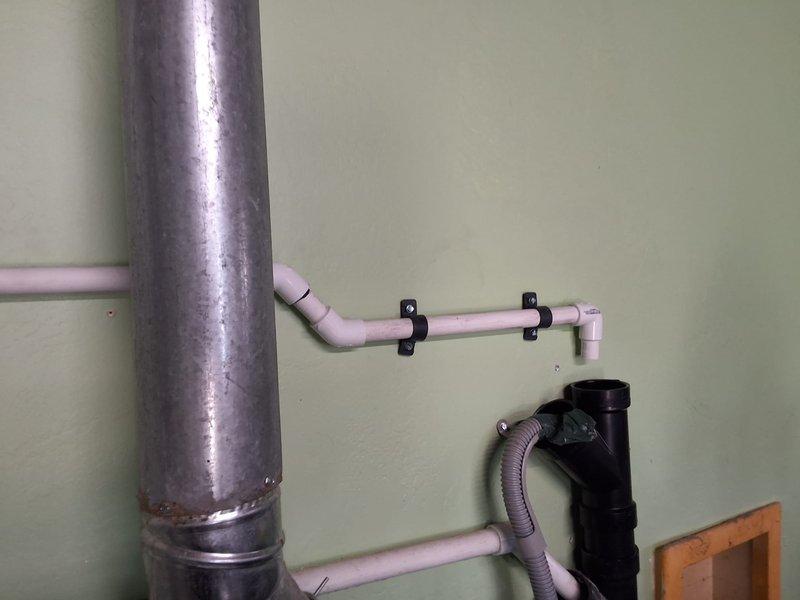 Relocated tankless water heater venting system that was originally installed directly above a window, repositioning exhaust termination to meet code compliance requirements. Corrected water valve placement that was improperly located and spaced too close together per inspector's findings. Completed warranty corrections on NPE-210S2 tankless unit to bring installation into full compliance with building codes and manufacturer specifications.