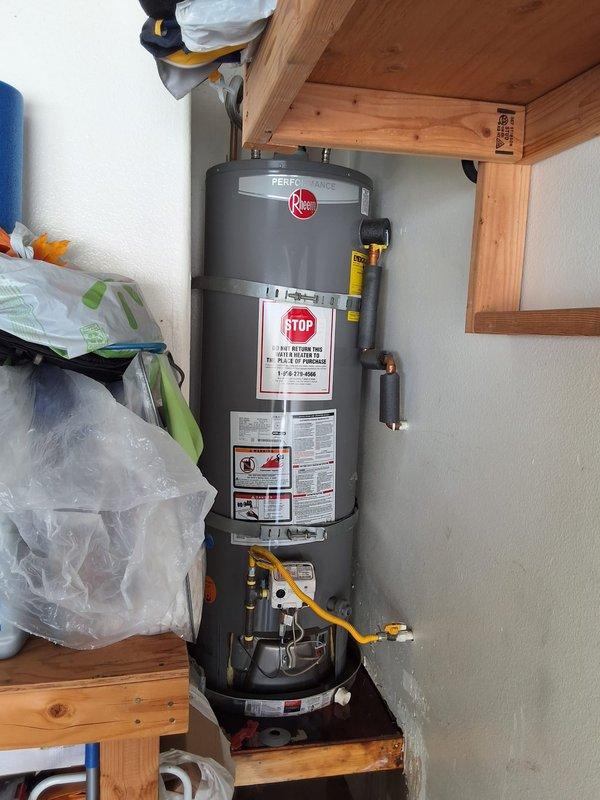 Responded to service call for leaking residential water heater located in condo garage with living space above. Upon inspection, determined existing 40-50 gallon atmospheric vent unit required replacement. Due to installation location in enclosed garage space beneath occupied room, recommended and installed power vent or direct vent water heater to meet current safety codes and building requirements for this configuration.

Successfully removed failed water heater and installed new Rheem Performance series gas water heater with appropriate venting system. Installation included connecting gas supply line, cold water inlet and hot water outlet with proper shut-off valves, installation of temperature and pressure relief valve with discharge piping, and complete power vent or direct vent exhaust system with proper termination. All connections tested for leaks and proper operation. Unit fired successfully and achieved proper temperature settings. Advised customer of permitting requirements 
