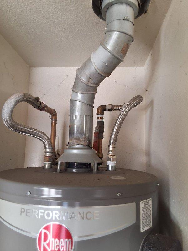 Responded to service call for leaking residential water heater located in condo garage with living space above. Upon inspection, determined existing 40-50 gallon atmospheric vent unit required replacement. Due to installation location in enclosed garage space beneath occupied room, recommended and installed power vent or direct vent water heater to meet current safety codes and building requirements for this configuration.

Successfully removed failed water heater and installed new Rheem Performance series gas water heater with appropriate venting system. Installation included connecting gas supply line, cold water inlet and hot water outlet with proper shut-off valves, installation of temperature and pressure relief valve with discharge piping, and complete power vent or direct vent exhaust system with proper termination. All connections tested for leaks and proper operation. Unit fired successfully and achieved proper temperature settings. Advised customer of permitting requirements 