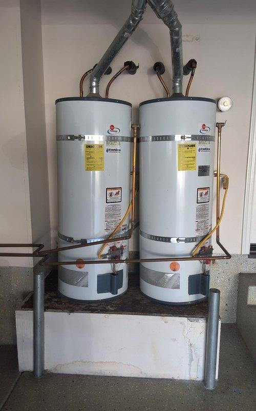 Replaced two aging 50-gallon gas water heaters (original units from 2005) due to leaking at top connections. Installed two new GN50T1-3-6 gas water heaters side by side in garage on elevated platform with proper venting, copper supply lines, pressure relief valves, and all required code-compliant connections and modifications. Permit obtained for installation.