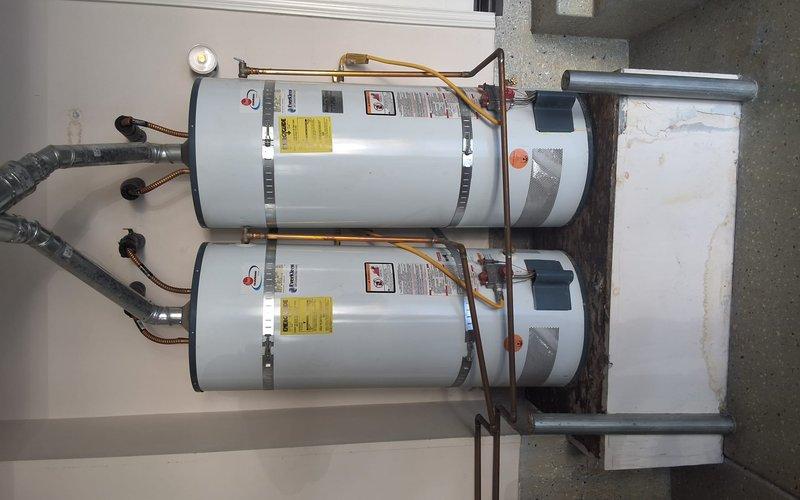Replaced two aging 50-gallon gas water heaters (original units from 2005) due to leaking at top connections. Installed two new GN50T1-3-6 gas water heaters side by side in garage on elevated platform with proper venting, copper supply lines, pressure relief valves, and all required code-compliant connections and modifications. Permit obtained for installation.