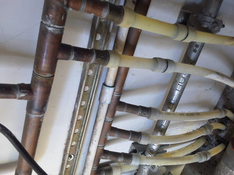 Performed inspection and provided estimate for a 10-year-old tankless water heater system showing signs of age and wear. Evaluated existing plumbing configuration including copper supply lines, PVC venting, and gas connections, noting surface discoloration and aging components throughout the installation. Discussed replacement options for tankless water heating system, permit requirements for installation, and available payment methods with property owner, and documented existing conditions with photographs.