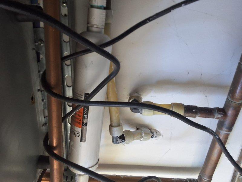 Performed inspection and provided estimate for a 10-year-old tankless water heater system showing signs of age and wear. Evaluated existing plumbing configuration including copper supply lines, PVC venting, and gas connections, noting surface discoloration and aging components throughout the installation. Discussed replacement options for tankless water heating system, permit requirements for installation, and available payment methods with property owner, and documented existing conditions with photographs.