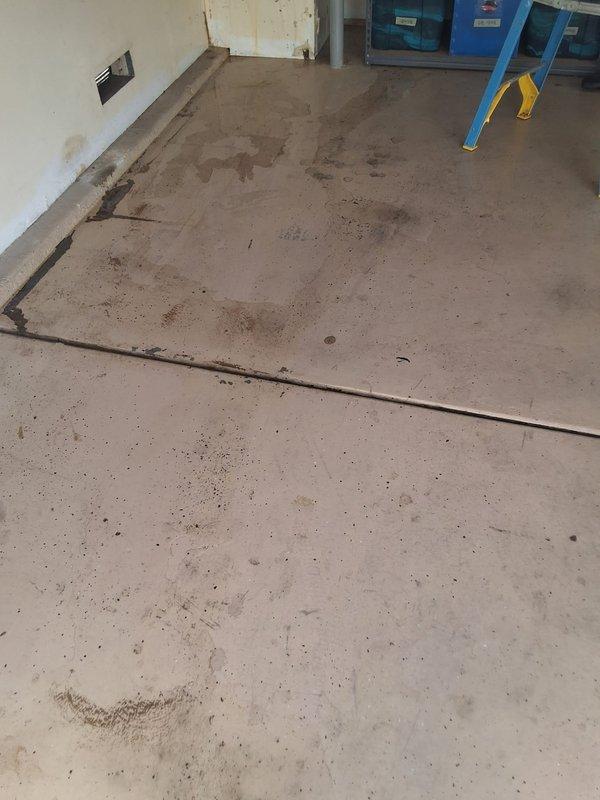 Responded to property management work order for reported leaking water heater. Upon arrival, located 40-50 gallon gas water heater in residential garage. Performed thorough inspection and evaluation of unit to identify source of leak and assess overall condition. Documented findings with photographic evidence showing garage layout and floor conditions with visible water staining and discoloration on concrete surface near unit location. Contacted office from site to report evaluation findings and await pricing approval per property management protocol before proceeding with recommended repairs or replacement.