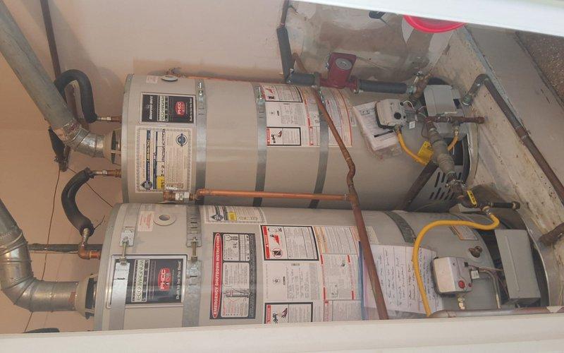 Responded to no hot water complaint affecting three showers in residence equipped with dual URG275H6N water heater system. Upon inspection, found recirculation valve in closed position, restricting hot water flow throughout distribution system. Opened ball valve to restore proper circulation and verified adequate hot water delivery to all affected fixtures, resolving customer complaint with no additional repairs required.