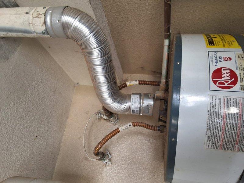 Performed inspection and estimate on 20-year-old Rheem water heater model 41ZR50N currently functioning properly. Customer requested evaluation for conversion from traditional tank-style water heater to tankless system. Discussed permit requirements for tankless installation and provided ballpark estimate range for complete tankless water heater swap-out, including removal of existing unit, installation of new tankless system, and necessary modifications to venting, gas lines, and electrical connections. Documented current installation with photos showing existing venting configuration with flexible aluminum ductwork, copper supply lines, and pressure relief valve assembly.