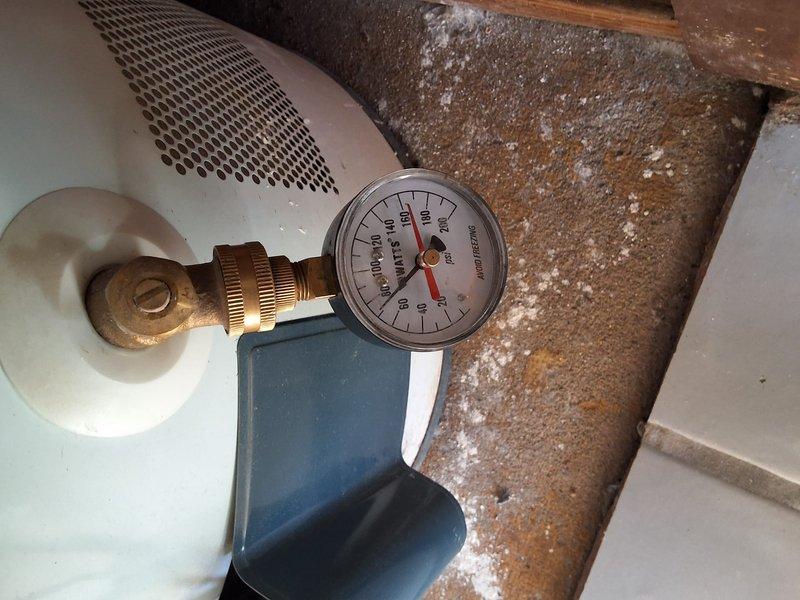 Performed inspection and estimate on 40-gallon gas water heater with reported intermittent pressure issues to hot water line. Upon examination, discovered extensive corrosion and mineral deposit buildup on water heater components, with pressure gauge testing conducted to verify system performance. Documented severe deterioration of tank exterior and significant condensation accumulation on connected piping, indicating potential system failure. Discussed permit requirements and provided ballpark estimate for replacement installation.