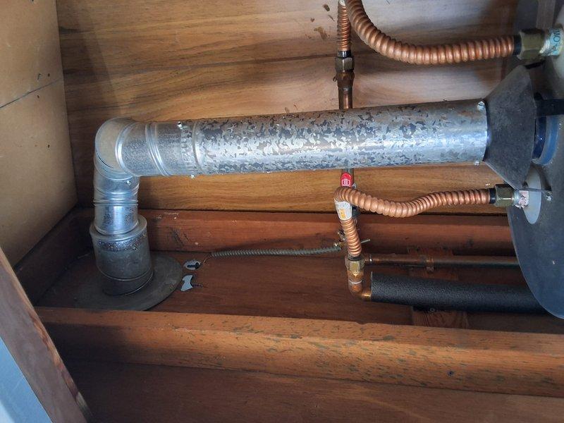 Performed inspection and estimate on 40-gallon gas water heater with reported intermittent pressure issues to hot water line. Upon examination, discovered extensive corrosion and mineral deposit buildup on water heater components, with pressure gauge testing conducted to verify system performance. Documented severe deterioration of tank exterior and significant condensation accumulation on connected piping, indicating potential system failure. Discussed permit requirements and provided ballpark estimate for replacement installation.
