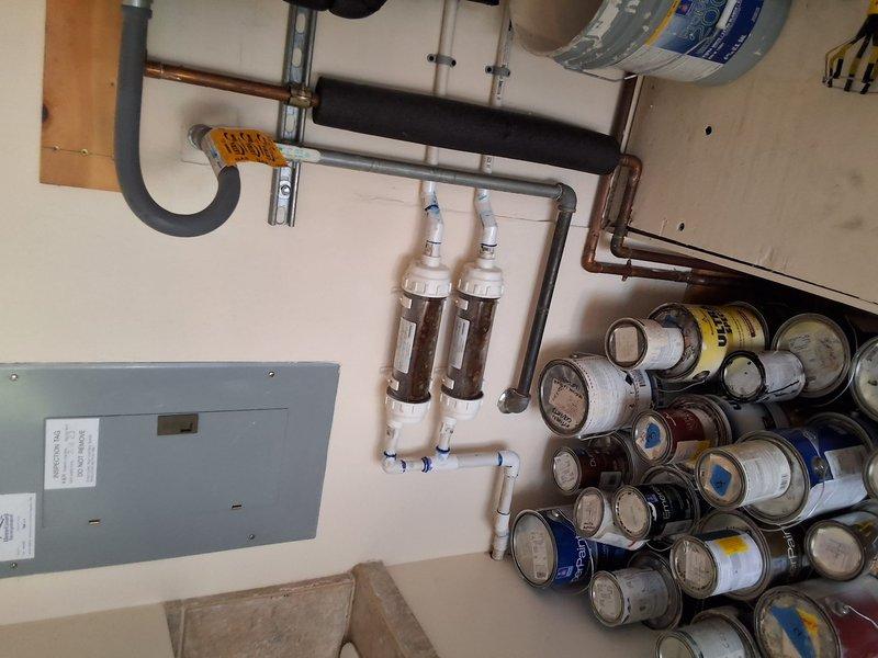 Responded to service call for reported tankless water heater leak. Upon arrival, conducted comprehensive diagnostic inspection of the water heating system and associated plumbing infrastructure. Performed visual assessment of all piping connections, valves, and mounting hardware to identify source of reported leak. Documented existing plumbing configuration including black PEX piping system, expansion tanks, filtration equipment, and electrical connections. Photographed installation for service records showing dual water heater setup with complex manifold system and support structure. Inspected all visible joints, fittings, and pressure relief components for signs of active water seepage or moisture accumulation. System appeared to be relatively recent installation based on condition of components and materials observed.