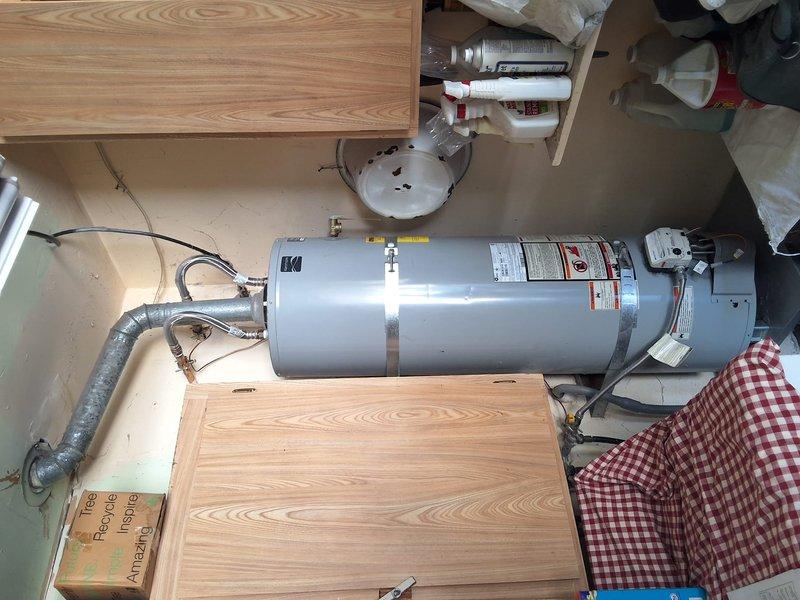 Responded to urgent service call for 40-gallon Kenmore natural gas water heater (S#: 1223T463870) with reported thermostat malfunction, no hot water production, and pilot light issues. Upon inspection, identified unit as subject to manufacturer recall, rendering repair unsafe and prohibited. Documented existing installation configuration including flexible supply lines, PVC venting, and electrical connections. Advised customer that recall status prevents any repair work and provided free estimate for replacement unit installation.