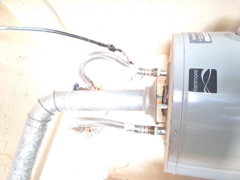 Responded to urgent service call for 40-gallon Kenmore natural gas water heater (S#: 1223T463870) with reported thermostat malfunction, no hot water production, and pilot light issues. Upon inspection, identified unit as subject to manufacturer recall, rendering repair unsafe and prohibited. Documented existing installation configuration including flexible supply lines, PVC venting, and electrical connections. Advised customer that recall status prevents any repair work and provided free estimate for replacement unit installation.