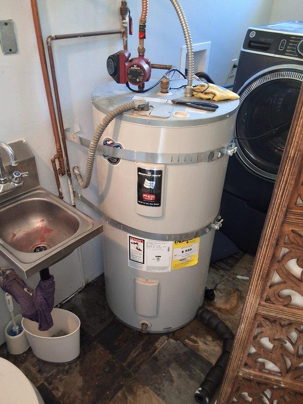 Responded to service call for leaking water heater flex line. Upon arrival, inspected 50-gallon electric Bradford White water heater model RE350S6 and identified active leak originating from flexible supply line connection above the unit. Evaluated the condition of both hot and cold water flex lines and associated copper piping connections. Documented equipment specifications and photographed the installation, including the recirculation pump system and overall plumbing configuration. Discussed repair options with property owner, including replacement of the failed flex line connection. Provided estimate for parts and labor to replace the leaking flexible connector, as well as option for complete water heater replacement if desired. Customer to advise on preferred course of action to resolve the leak issue.
