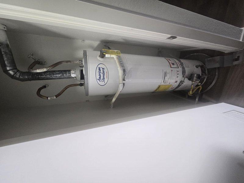 Responded to property management request for water heater replacement evaluation at multi-family residential unit. Accessed mechanical space and inspected existing 30-gallon gas water heater in interior closet configuration. Documented current system conditions including water supply pressure readings via installed gauge showing operational parameters within normal range. Observed existing water filtration system with dual-stage filter housings and braided supply lines in serviceable condition. Completed photographic documentation of equipment and surrounding infrastructure. Contacted office from site with findings per protocol for pricing approval before proceeding with replacement work.