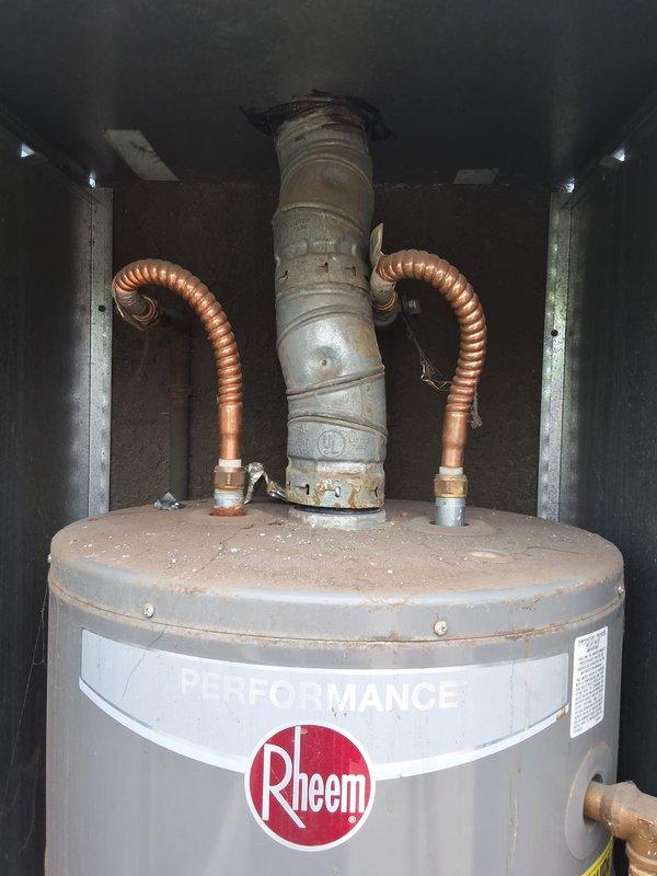 Performed inspection on a 7-year-old Rheem Performance 40-gallon gas water heater experiencing active leaking. Assessed unit condition, documented installation with photographs showing exterior cabinet enclosure, plumbing connections, copper flex lines, and vent piping. Provided estimate for replacement with new 40-gallon gas water heater, discussed permit requirements, and reviewed available payment options with property owner.